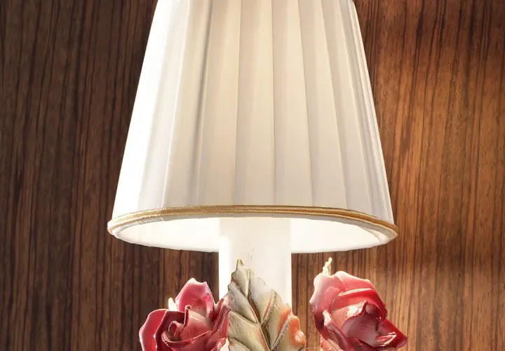 Elegancka lampka nocna z plisowanym abażurem i ceramicznymi różami u podstawy.