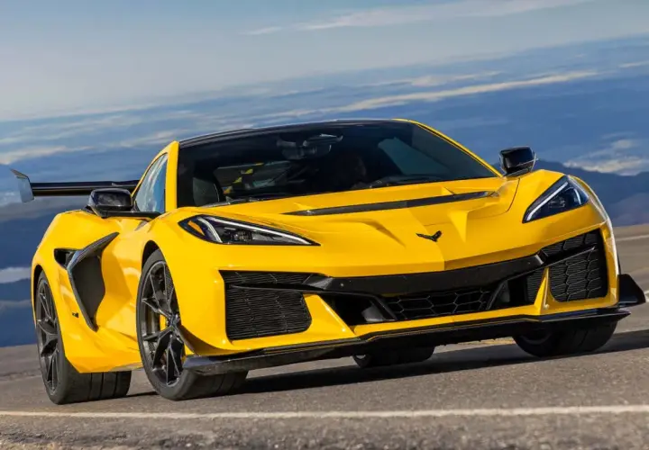 Żółty Chevrolet Corvette C7 ZR1 z dużym tylnym skrzydłem pędzi po górskiej drodze, gotowy na każde wyzwanie.