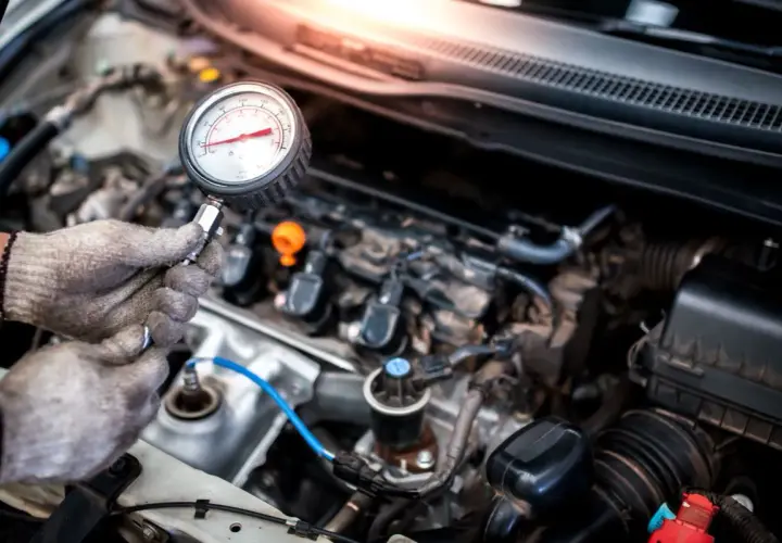 Mechanik sprawdza jakie minimalne ciśnienie sprężania diesel za pomocą manometru.