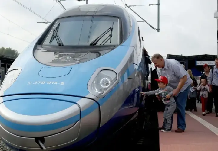 Rodzina podziwia nowoczesny pociąg Pendolino. Sprawdzają pociąg warszawa - gdańsk cena, by zaplanować podróż.