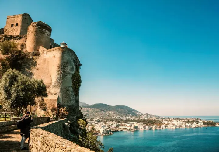 Antico castello a picco sul mare, con vista sulla costa di Ischia. Un fotografo cattura la bellezza del panorama, un ricordo di Ischia Castel Sant'Angelo.