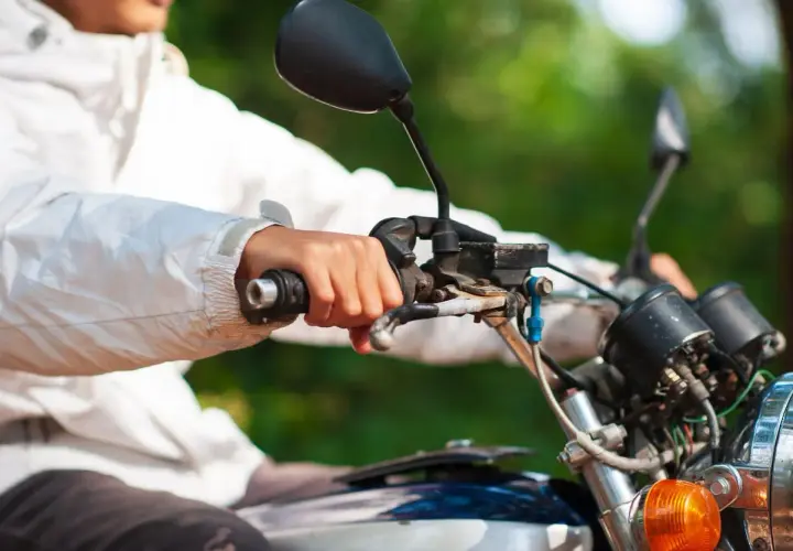 Mano sujetando el acelerador de una moto, con la llave del gas abierta, lista para la aventura.