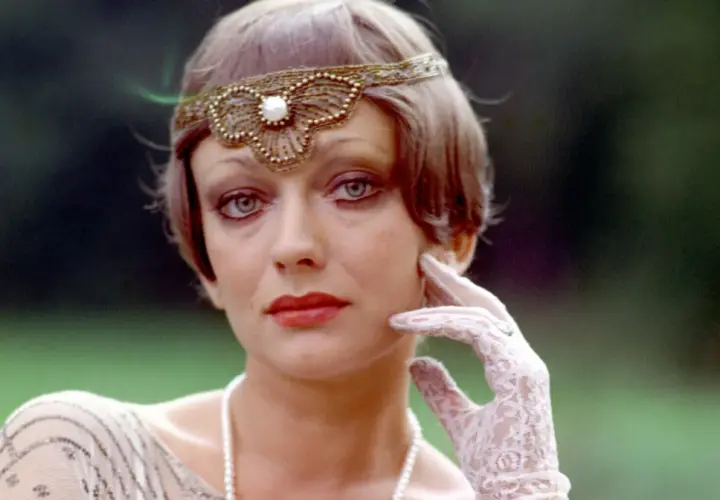 Ewa Szykulska w filmach, w stylizacji z lat 20. z opaską na głowie i koronkową rękawiczką.