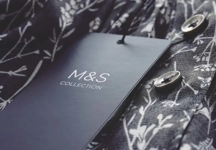Étiquette M&S Collection sur un tissu fleuri. Astuce pour savoir comment décoller une étiquette sans l'abimer.