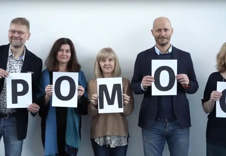 Pięć osób trzyma litery tworzące słowo POMOC. To przykład, co to altruizm – bezinteresowna pomoc innym.