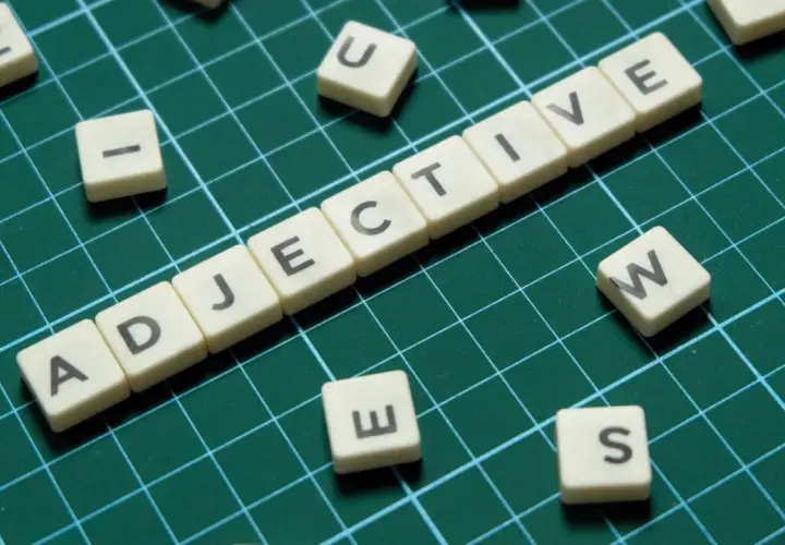 Tessere con lettere formano "ADJECTIVE". Alcune lettere sparse, come "S", suggeriscono la creazione di aggettivi con s.