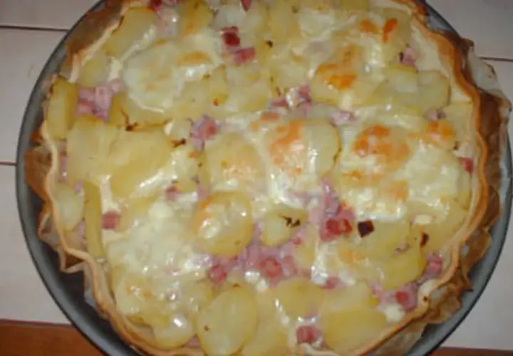 Tarte façon raclette, garnie de pommes de terre, lardons et fromage fondant. Un délice réconfortant !