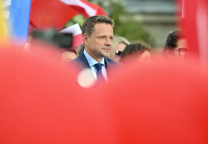 Kto stoi za nowym wizerunkiem kandydata KO na prezydenta i ile to kosztowało? Mężczyzna w garniturze na tle flag.
