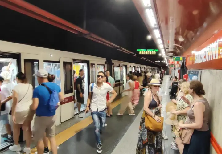 Persone in attesa del treno alla stazione Barberini di Roma.