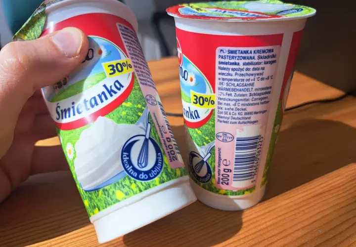 Dwie śmietanki 30% z karagenem, jedna w dłoni, gotowe do ubijania. Idealne do deserów.
