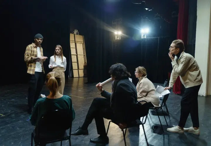 Aktorzy na próbie dyskutują o tym, ile zarabiają aktorzy w teatrze, analizując scenariusz.