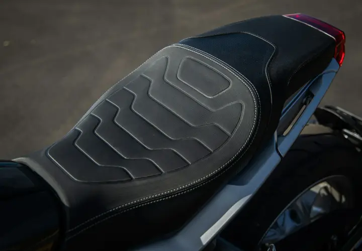 Cuscino sella moto fai da te con cuciture bianche e design geometrico. Comfort e stile per il tuo viaggio.