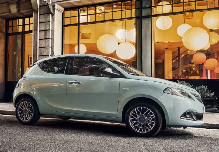 City car 5 posti azzurra parcheggiata davanti a una vetrina con lanterne luminose.