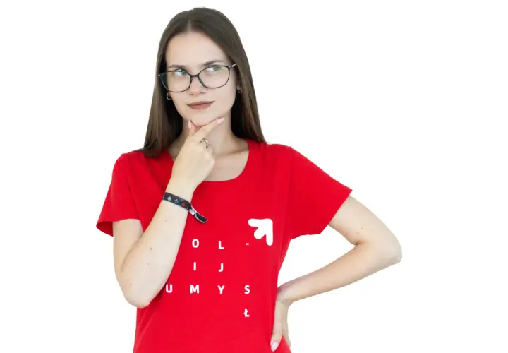 Młoda kobieta w okularach i czerwonej koszulce z napisem "OLIJ UMYSŁ" zastanawia się, czy jej pomysł jest ex aequo dobry jak inne.