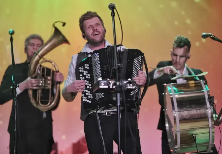 Bum bum orkestar w akcji: akordeonista, tubista i perkusista tworzą energetyczną muzykę na scenie.