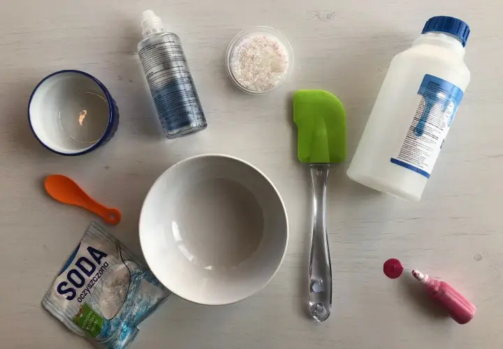 Składniki do zrobienia slime: klej, soda, boraks, brokat, miseczki, łyżeczka i szpatułka.