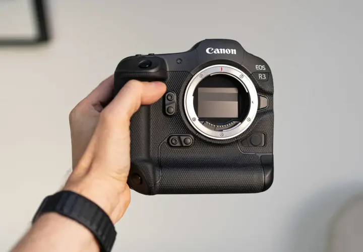 Dłoń trzyma aparat Canon EOS R3. Profesjonalny sprzęt gotowy do akcji.