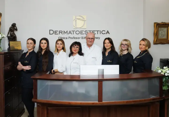 Zespół kliniki DERMATOESTETICA, gdzie przyjmuje Izabela Domitrz, pozuje do zdjęcia przy recepcji.
