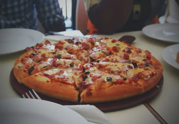 Pyszna, gorąca pizza z kurczakiem i cebulą, idealna do odgrzania zimnej pizzy.