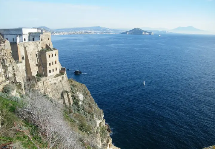 Vue depuis le fort de San Michele à Procida, surplombant la mer bleue. Au loin, des îles et le Vésuve.