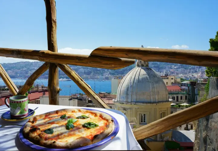 Pizza Margherita i kawa na stole z widokiem na Neapol.