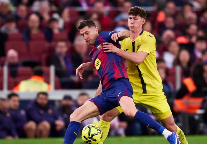 Piłkarz Barcelony Robert Lewandowski w akcji, walczy o piłkę z obrońcą. Kibice na trybunach obserwują mecz, martwiąc się o lewandowski kontuzja.
