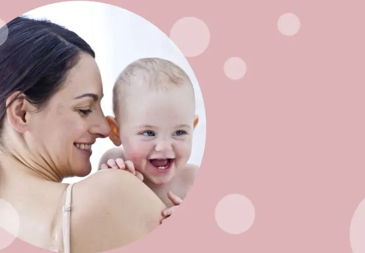 Uśmiechnięta mama tuli radosnego niemowlaka. Od kiedy oliwki dla niemowlaka? Pielęgnacja delikatnej skóry maluszka.
