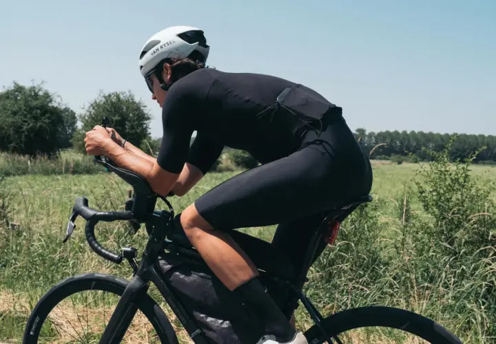 Kolarz w aerodynamicznej pozycji na rowerze szosowym, z pewnością doceniający najlepsze opony szosowe na tej trasie.