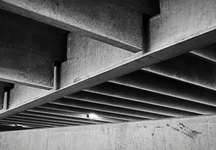 Skomplikowana konstrukcja z betonu, z widocznymi belkami i żebrowaniem. Ta klasa betonu tworzy surowy, architektoniczny krajobraz.