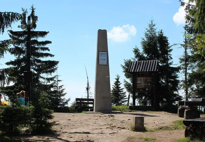 Na szczycie Turbacz, gdzie jest piękny widok, stoi obelisk. Wokół drzewa i ławki dla turystów.