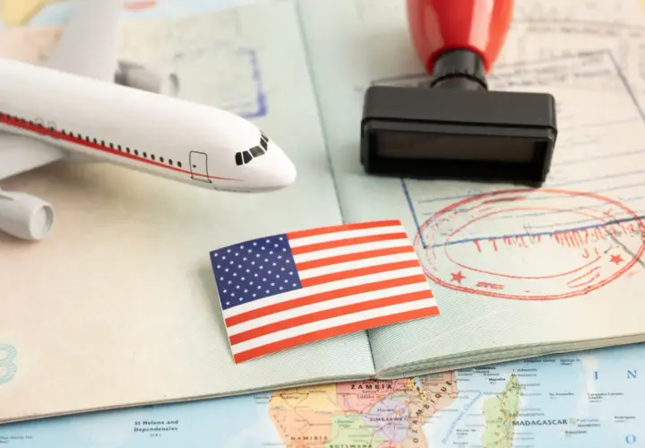 Flugzeugmodell, US-Flagge, Stempel und Pass auf einer Weltkarte. Perfekt für deine USA Reise Checkliste.