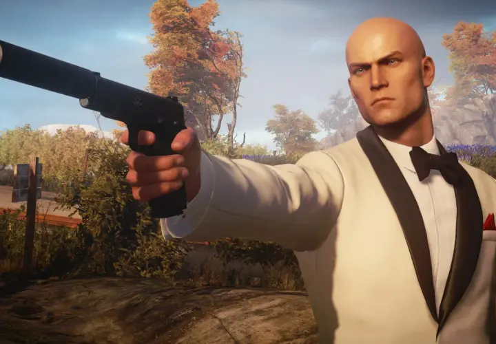 Agent 47 w białym smokingu z pistoletem, gotowy do akcji. Spolszczenie Hitman 3 sprawia, że misje są jeszcze bardziej wciągające.