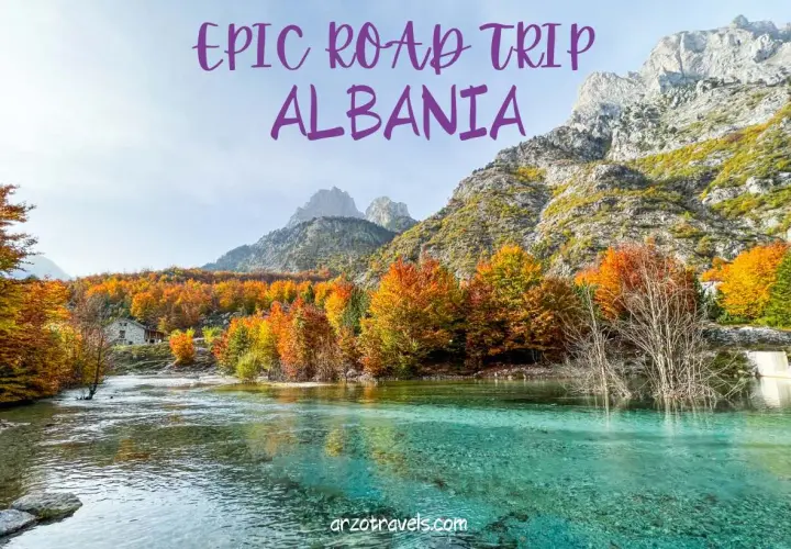 An epic road trip through Albania reveals a stunning turquoise river flowing past a stone house, with mountains and vibrant autumn foliage.