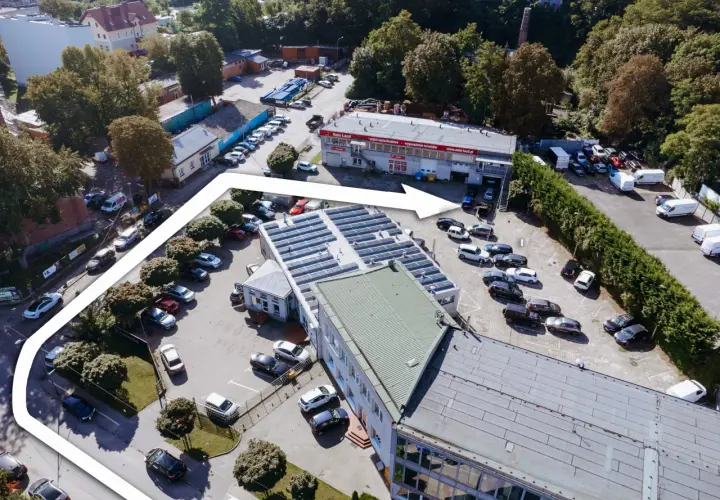Widok z lotu ptaka na teren firmy Elektromatic Krawczyk Michał, z parkingiem pełnym samochodów i budynkami.