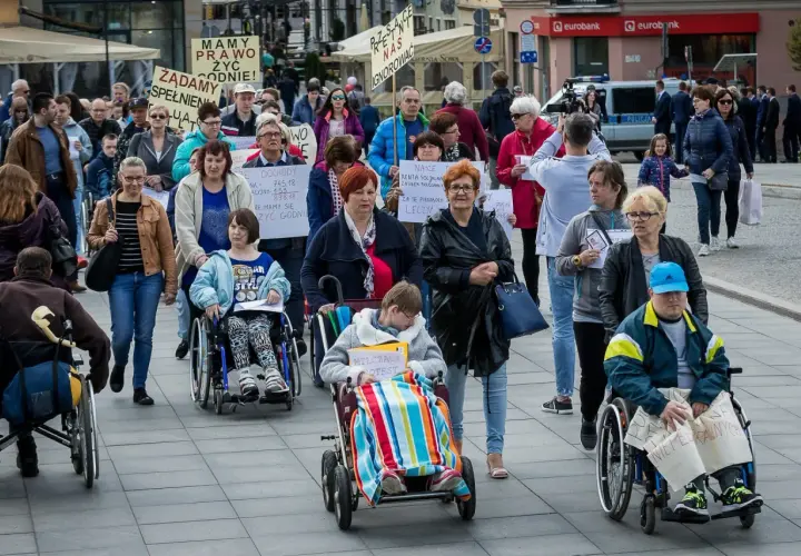 Protest osób na wózkach inwalidzkich. Pytanie: czy dodatek pielęgnacyjny wlicza się do 500 plus dla niepełnosprawnych?