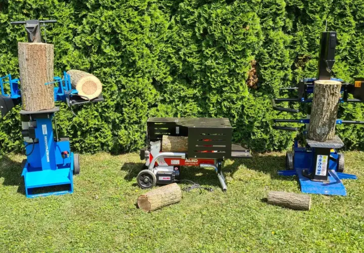Zwei Holzspalter, einer mit Zapfwelle und ein elektrischer, stehen bereit, um Holz zu spalten.