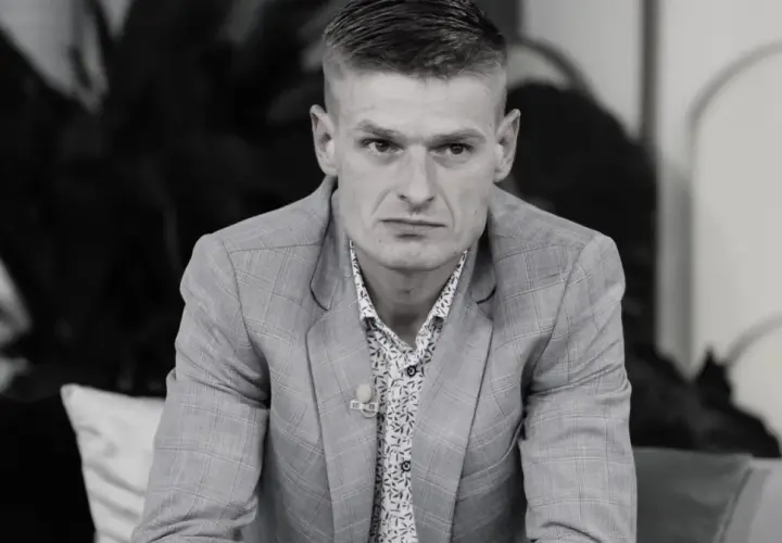Tomasz Komenda, mimo młodego wieku, ma za sobą trudne doświadczenia. Na zdjęciu w garniturze i wzorzystej koszuli.