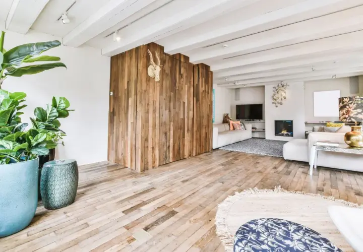 Nowoczesny salon z drewnianą ścianką i podłogą. Płytki drewnopodobne w salonie aranżacje tworzą ciepły klimat.