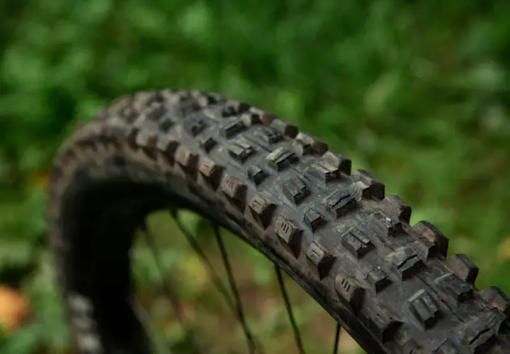Close-up of a Maxxis Assegai tire, showing its aggressive tread pattern. This tire is ready for any trail.