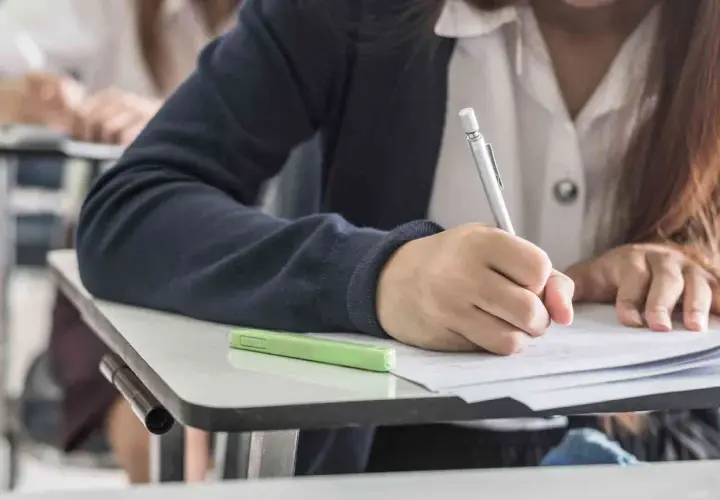 Uczeń pisze wypracowanie, ćwicząc użycie gerund i bezokolicznika.