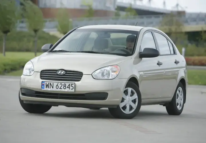 Złoty Hyundai Accent z polskimi tablicami WN 62845 zaparkowany na zewnątrz.