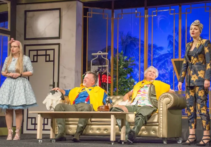 Aktorzy na scenie Teatru Komedia Wrocław, w barwnych strojach, przygotowują się do występu.