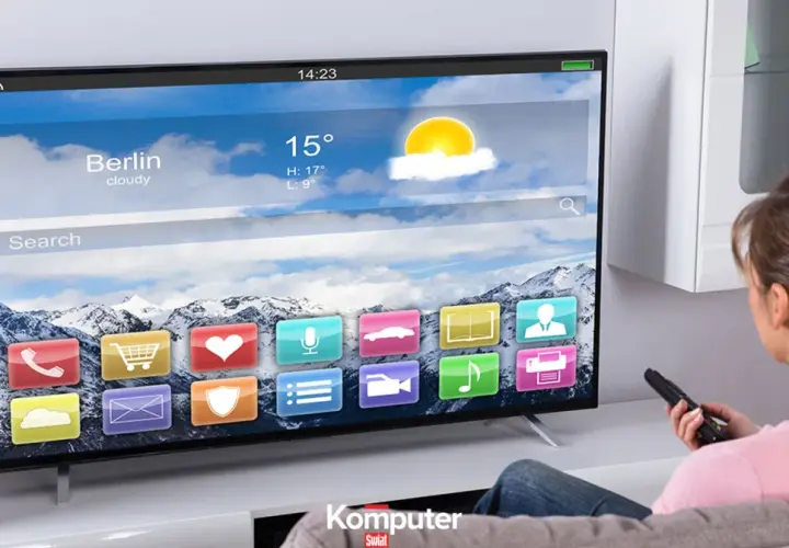 Kobieta z pilotem ogląda nowoczesny telewizor LCD, na którym wyświetla się interfejs z ikonami aplikacji i prognozą pogody dla Berlina.