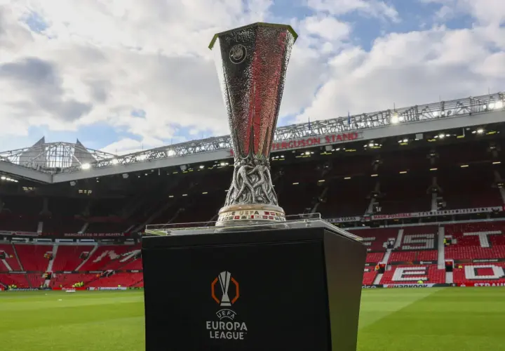 Trofeum Ligi Europy na tle stadionu Old Trafford. Marzenie o tym, by zdobyć ten puchar, jest bliskie spełnienia dla wielu drużyn.