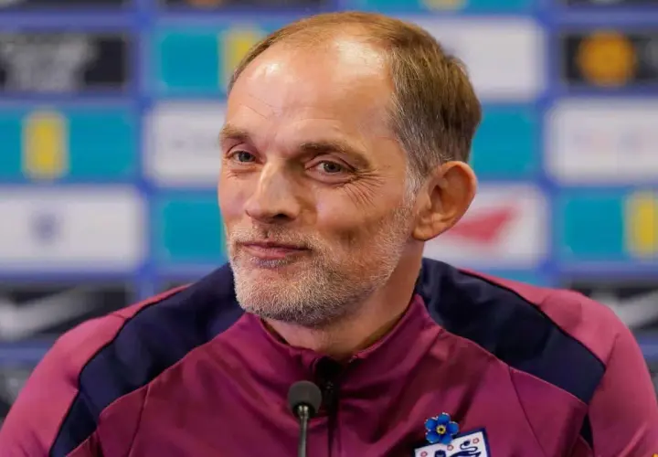 Thomas Tuchel, były trener Chelsea, w bordowej kurtce z niebieskimi wstawkami, z przypinką w kształcie niebieskiego kwiatka.