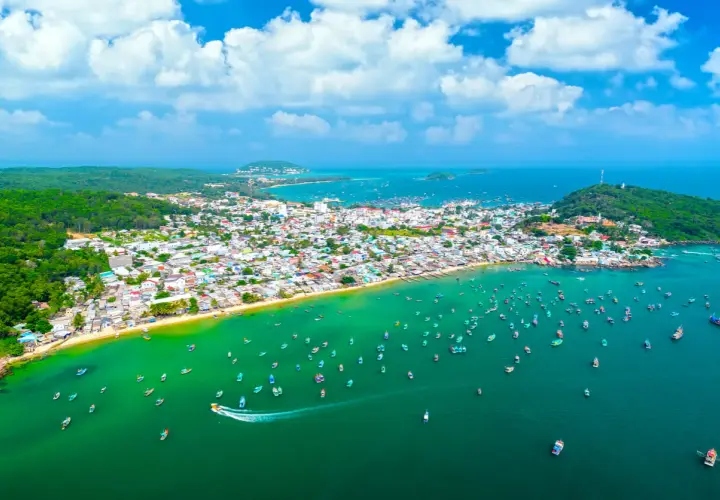 Luftaufnahme einer Küstenstadt mit vielen Booten im türkisfarbenen Meer. Perfekt für die phu quoc beste reisezeit.