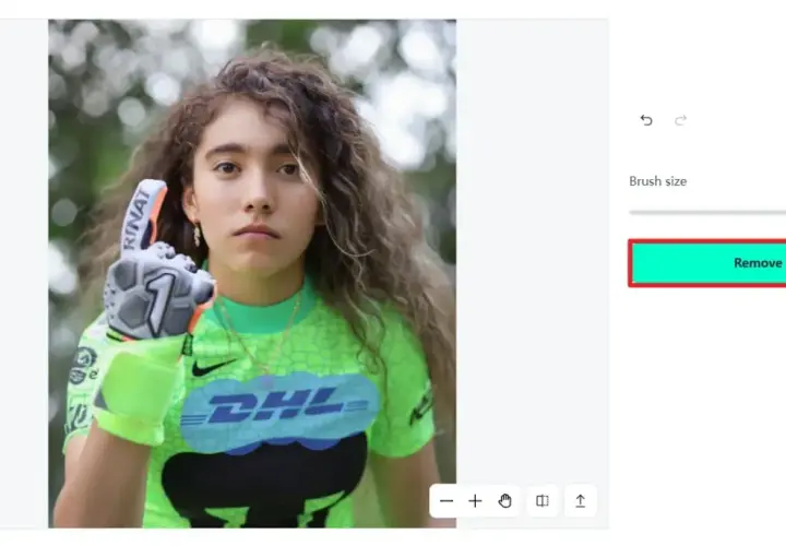 Jeune gardienne de but avec un gant, prête à enlever logo sur son maillot vert fluo.