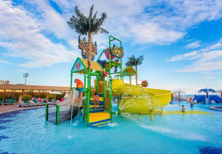 Kolorowy aquapark z palmami i zjeżdżalniami, idealne miejsce na wakacje w Eftalia. Dzieci bawią się w wodzie.