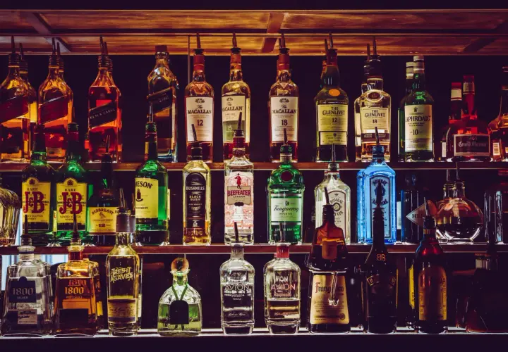 Rzędy butelek z whisky i innymi alkoholami. Zastanawiasz się, ile kropel wody dodać do whisky, by "otworzyć" jej aromat i smak?