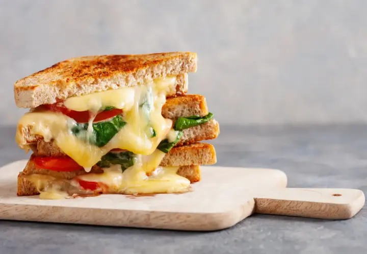 Un délicieux sandwich grillé aux tomates et épinards, une idée sandwich froid simple et gourmande. Le fromage fondant coule sur les tranches de pain.